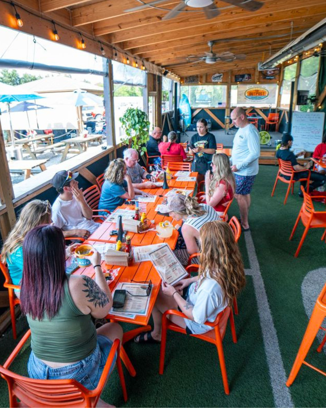 Large group dining together on the patio at The Outpost
