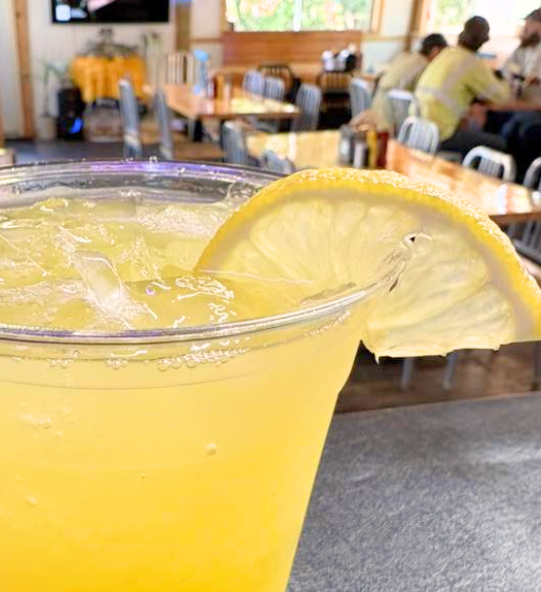 Ice-cold lemon cocktail garnished with a lemon wheel on the patio
